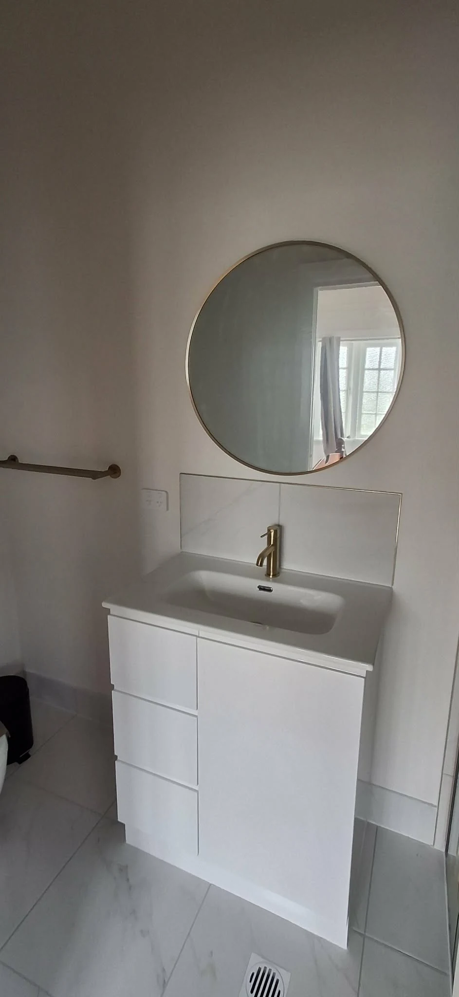 Completed bathroom vanity and round mirror